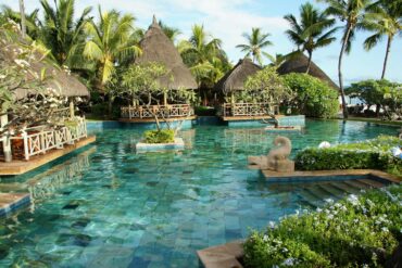 a tropical resort pool offering luxury, privacy, and relaxation. cabanas in the background.