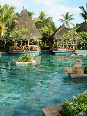 a tropical resort pool offering luxury, privacy, and relaxation. cabanas in the background.
