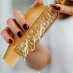 Close-up image of grated parmesan cheese with focus on hands and food preparation.