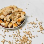 Flat lay of tofu cubes drizzled with soy sauce and sprinkled with sesame seeds