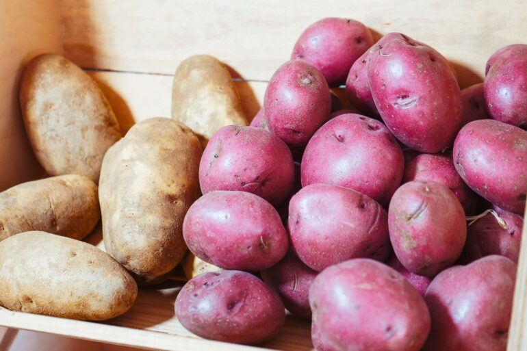 a drawer full of white and red potatoes