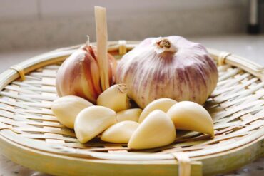 a basket full of garlic bulbs and cloves
