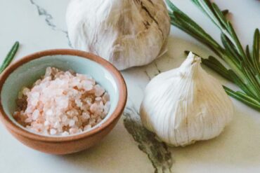 garlic bulbs on a counter with a bowl of minced garlic