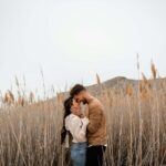 A man and a woman standing in a field of tall grass This couple was so in love as they explored the beautiful nature around them.