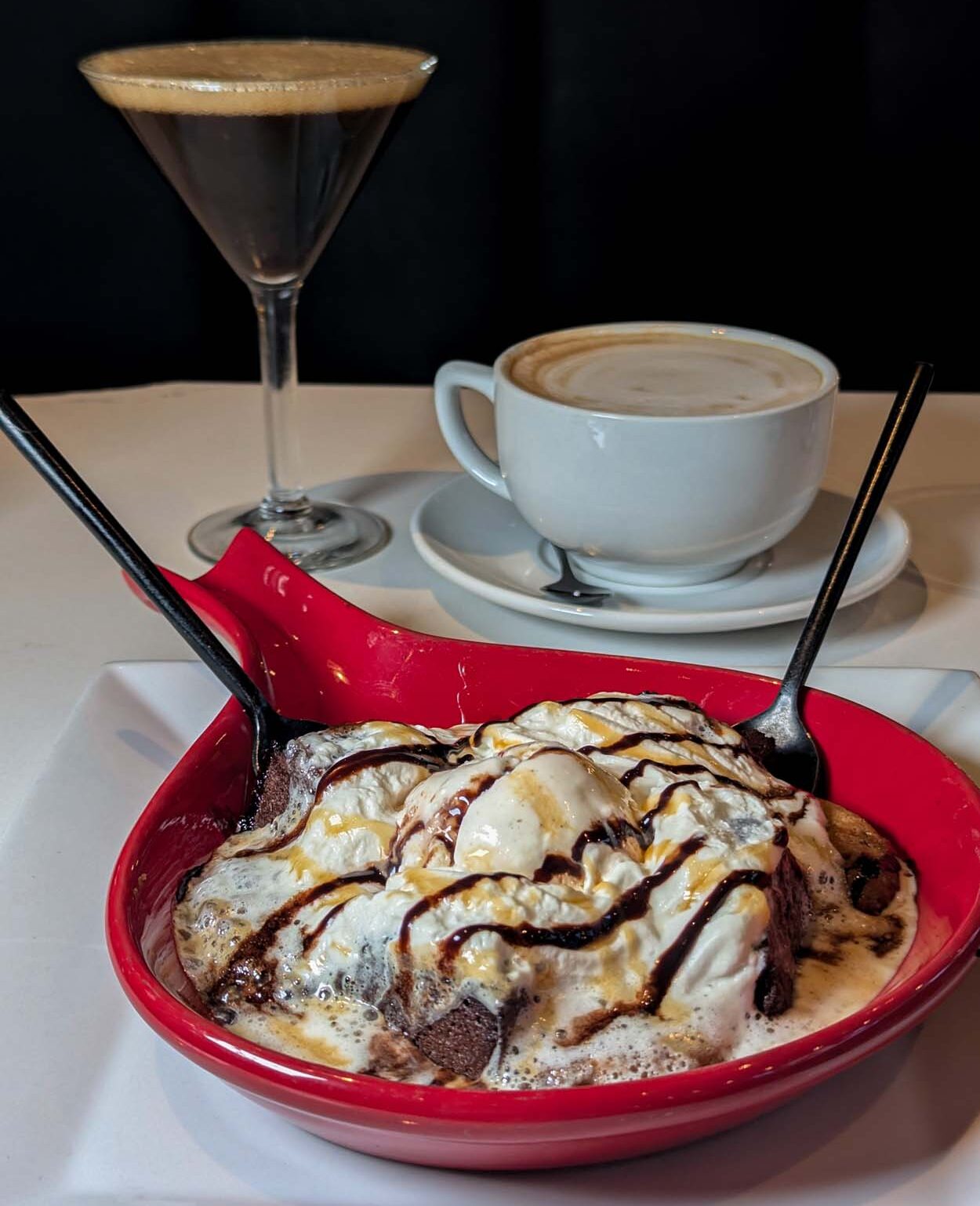 LaScala Cookie Skillet, David's Chocolate Chip Cookies and Brownies baked to order with caramel syrup, shaved chocolate, and vanilla ice cream next to espresso martini and cappuccino