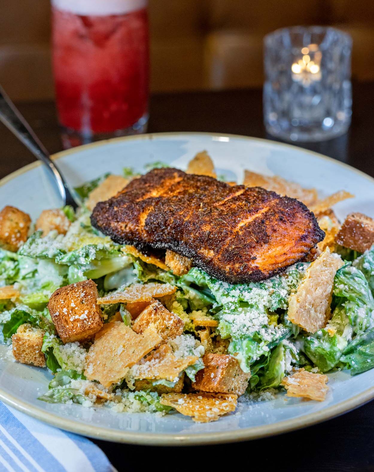 Caesar salad with a blackened salmon fillet at lak restaurant at Merriweather Lakehouse Hotel with parmesan crisps croutons and a red cocktail alongside