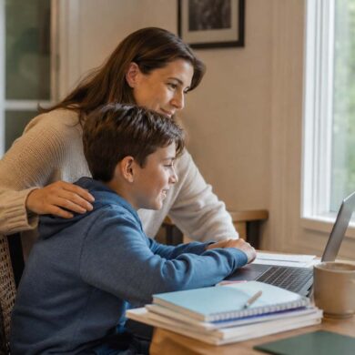 Parent and child looking at a laptop together during a home-based online school session, illustrating mid-year enrollment support