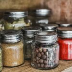 Close-up of assorted spice jars with various herbs on a kitchen shelf, showcasing colorful culinary ingredients