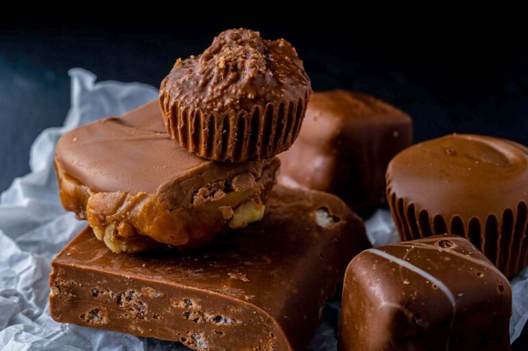 A delectable assortment of chocolate desserts including fudge and peanut clusters.