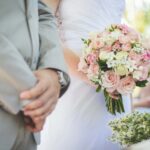 a couple at the alter getting married. up close shot of their hands and bouquet.