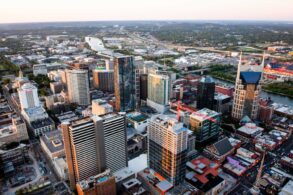 Stunning aerial cityscape of Nashville, Tennessee featuring skyscrapers and urban layout at sunset.