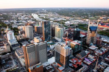 Stunning aerial cityscape of Nashville, Tennessee featuring skyscrapers and urban layout at sunset.