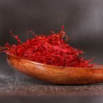 Detailed close-up of vibrant saffron threads in a wooden spoon