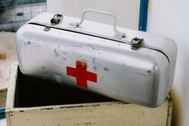 an old metal first aid kit in storage, possibly filled with expired items