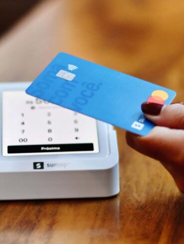 a person holding a credit card in front of a machine