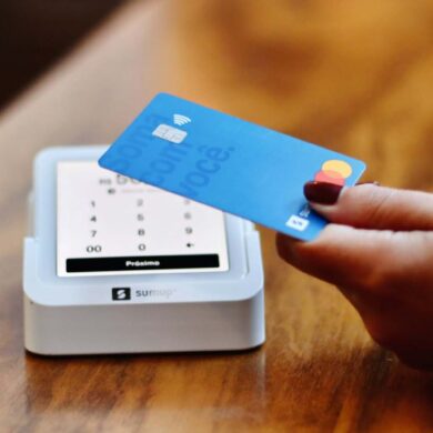a person holding a credit card in front of a machine