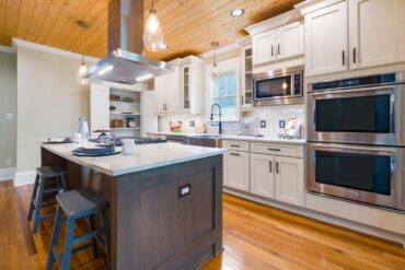 Spacious modern kitchen with wooden accents and an island countertop.