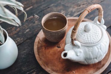 white and brown ceramic teapot on wooden tray