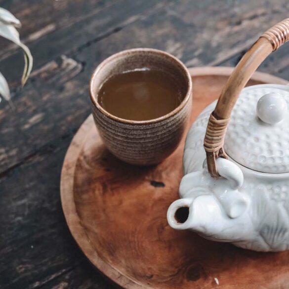 white and brown ceramic teapot on wooden tray