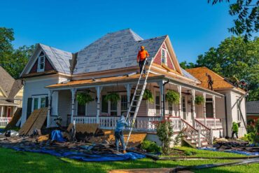 Roofers replace the roof of a historic home