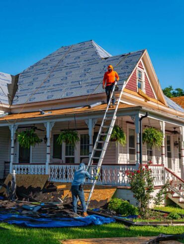 Roofers replace the roof of a historic home