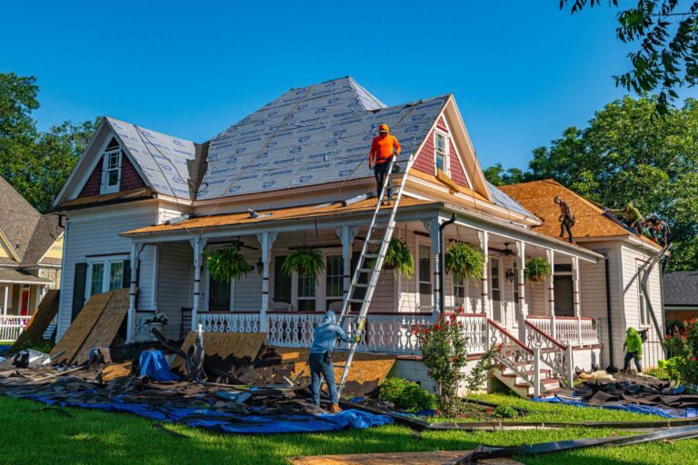 Roofers replace the roof of a historic home