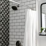a modern titled bathroom with the shower curtain left open