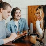 a group of young college students having a fun conversation at a dining table