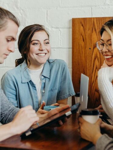 a group of young college students having a fun conversation at a dining table