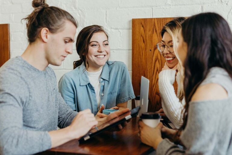 a group of young college students having a fun conversation at a dining table