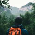 A man hiking in a blue and orange hoodie wearing black knit cap and backpack at Grands-Jardins National Park, Québec, Canada