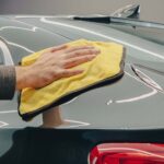 a person hand waxing their car with Turtle Wax