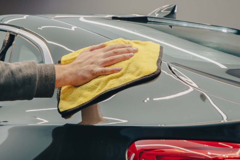 a person hand waxing their car with Turtle Wax