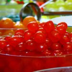 A large bowl of Maraschino cherries on a table in a party atmosphere