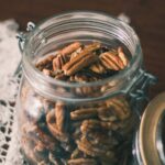a mason jar of whole pecans on a table