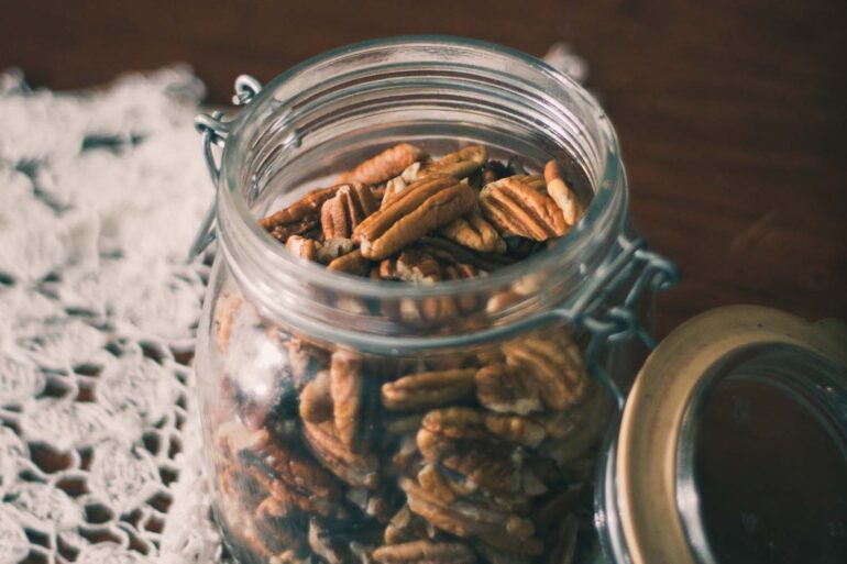 a mason jar of whole pecans on a table