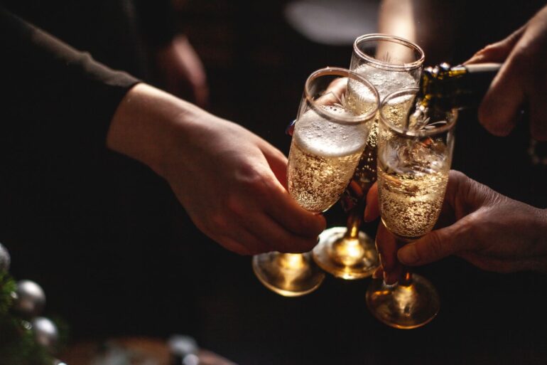 a close up of 3 people toasting champagne in a party setting