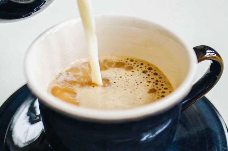up close shot of coffee mate being poured into a cup of coffee