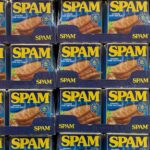 a supermarket shelf stacked with cans of Spam