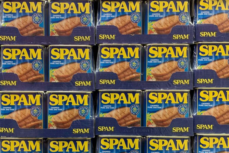 a supermarket shelf stacked with cans of Spam