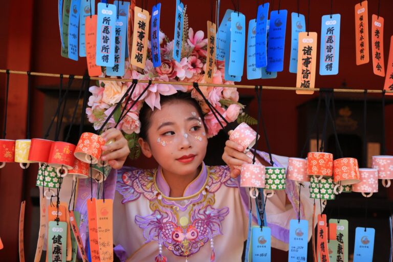 A young Asian woman in traditional attire surrounded by vibrant lanterns and wishes, capturing cultural celebration.
