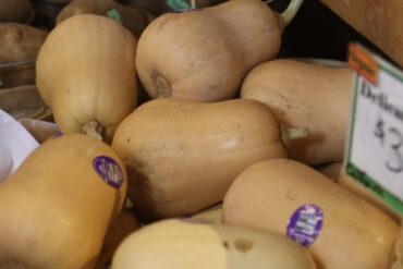 a box of butternut squash on sale in a grocery store