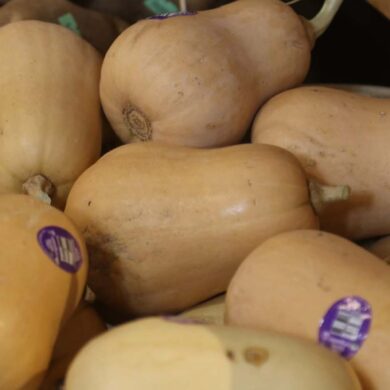 a box of butternut squash on sale in a grocery store