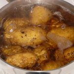A large pot filled with water and potatoes coming to boil