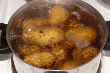 A large pot filled with water and potatoes coming to boil