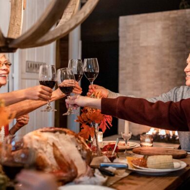 A family celebrates around a Thanksgiving table toasting wine