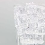 an up close shot of a glass of bubbly club soda and ice