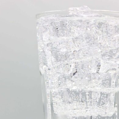 an up close shot of a glass of bubbly club soda and ice