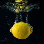 close up of a whole lemon being dropped into water